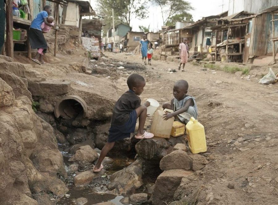 Boys take water on a street of Kibera, Nairobi, Kenya.