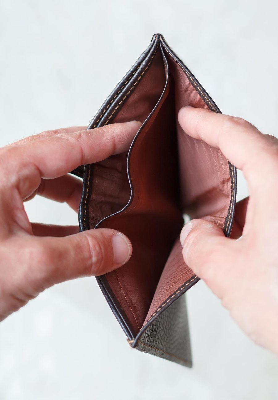 Hands holding an open wallet with no money